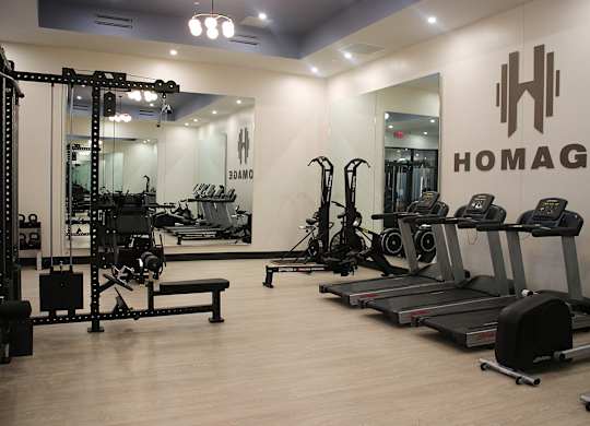 A gym with a variety of equipment including treadmills, weights, and exercise machines.