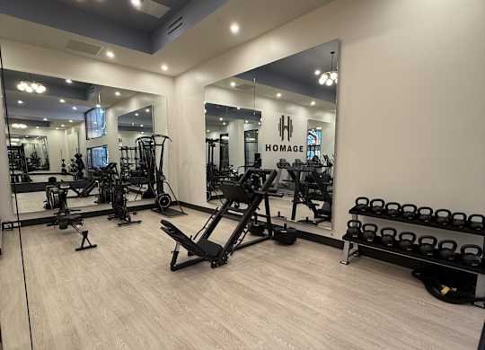 A gym with a mirror, weights, and exercise equipment.