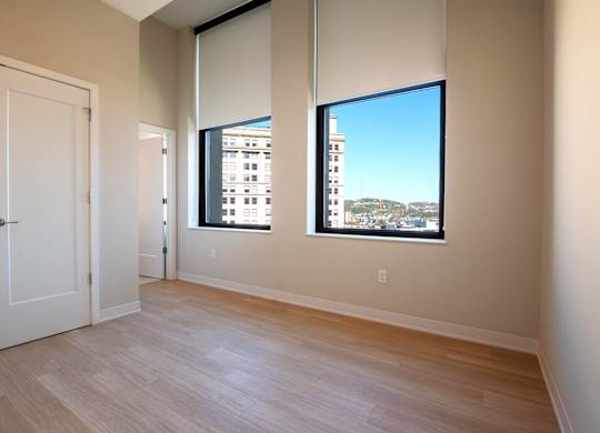 A room with a large window and a wooden floor.