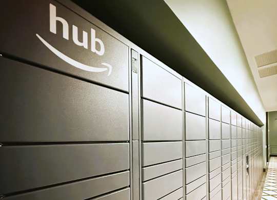 A row of Amazon hub lockers are lined up in a hallway.
