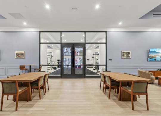 A room with a long table and chairs in front of a glass door at LiveWell Apartments, Pennsylvania, 15222