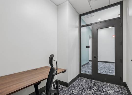 A room with a wooden table and a black chair. at LiveWell Apartments, Pittsburgh, Pennsylvania