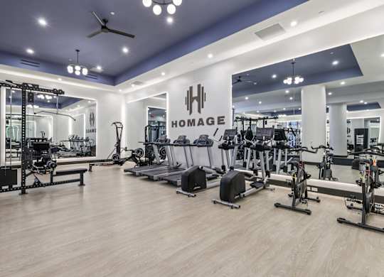 A gym with a variety of equipment including treadmills, weights, and exercise bikes. at LiveWell Apartments, Pittsburgh, PA