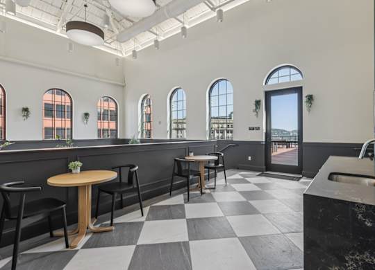 A black and white checkered floor in a room with a table and chairs. at LiveWell Apartments, Pittsburgh, PA