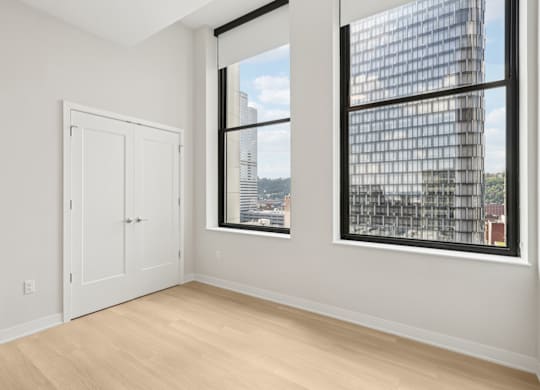A room with a large window and a view of a cityscape at LiveWell Apartments, Pittsburgh