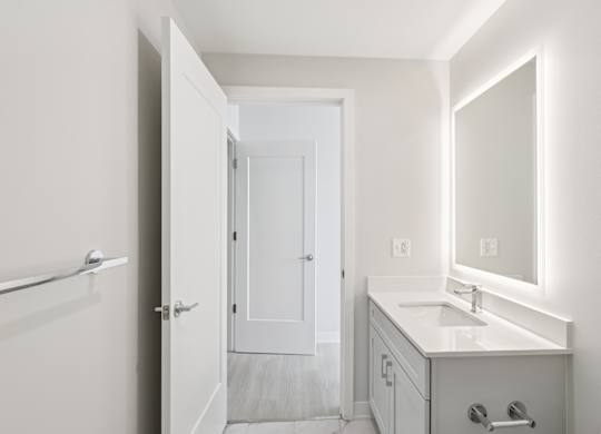 A white bathroom with a sink, mirror, and towel rack. at LiveWell Apartments, Pittsburgh, PA, 15222