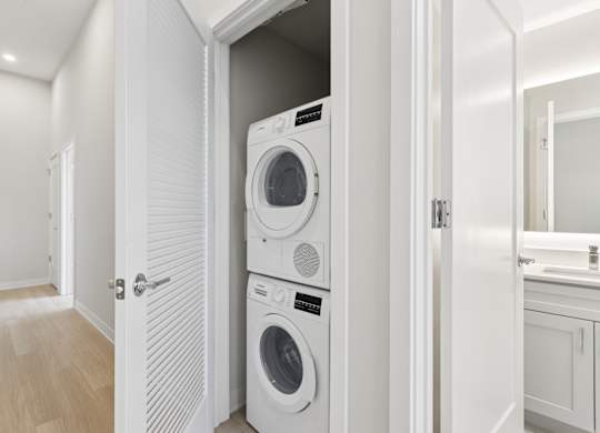A white washing machine and dryer in a small laundry room. at LiveWell Apartments, Pittsburgh, PA