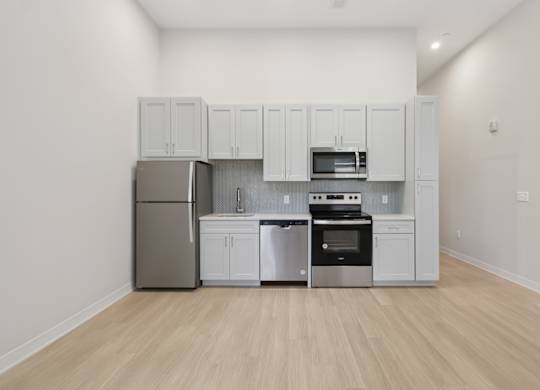 A kitchen with white cabinets and stainless steel appliances at LiveWell Apartments, Pittsburgh 15222