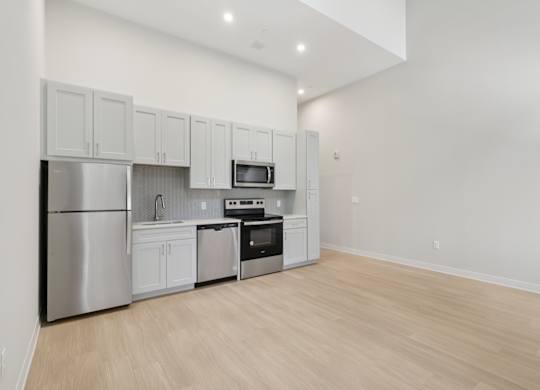 A kitchen with white cabinets and stainless steel appliances. at LiveWell Apartments, Pittsburgh, Pennsylvania