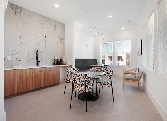 A living room with a leopard print chair and a wooden cabinet.