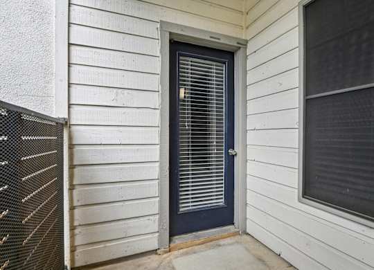 A white house with a dark blue door and window.