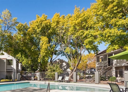 a swimming pool with a hot tub and a patio with chairs at Bella Vista, St. George