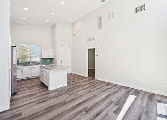Baseline on 16th townhome kitchen with white cabinets and a wooden floor.