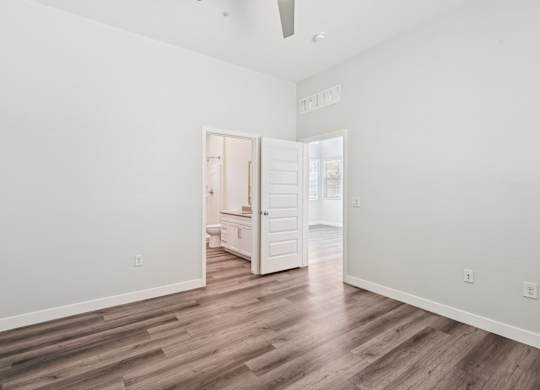 Baseline on 16th townhome bedroom with a wooden floor and a white ceiling with a fan.