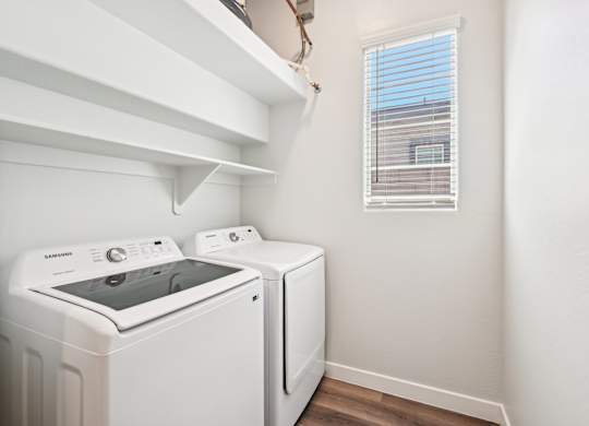 Baseline on 16th townhome white washing machine and dryer in a small laundry room.