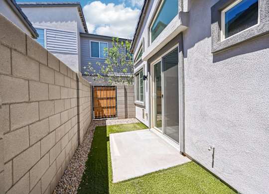 Baseline on 16th townhome backyard with a white exterior and a small garden area.