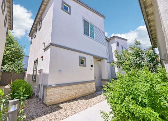 Baseline on 16th townhome with a grey roof and a small garden in front.