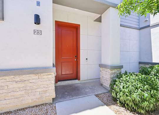 Baseline on 16th townhome red door is the entrance to a house with a stone wall.