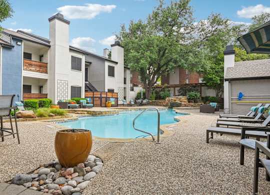 A pool surrounded by chairs and a large vase.