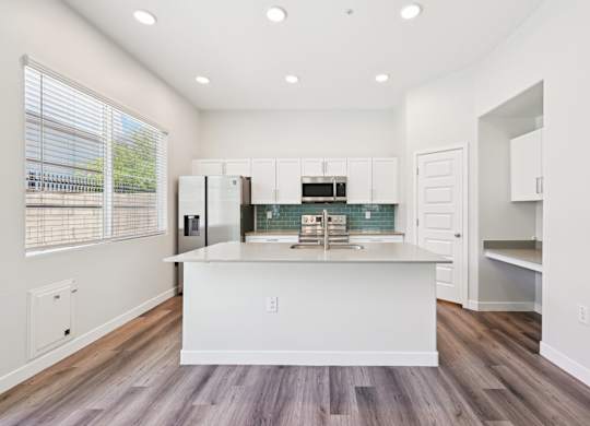 Baseline on 16th townhome kitchen with white cabinets and a large island.
