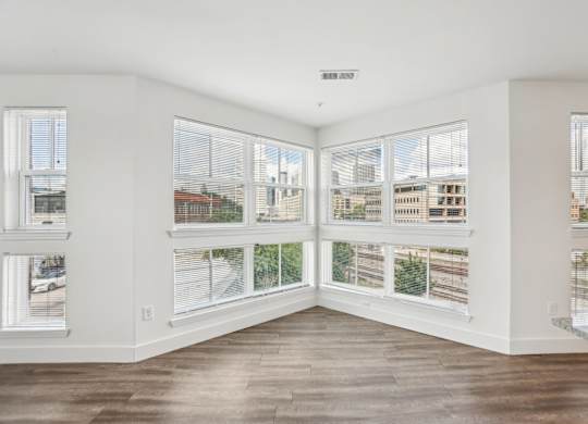 A room with a view of the city through large windows.