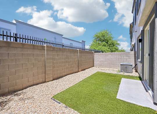 Baseline on 16th townhome backyard with a grassy area and a wall.