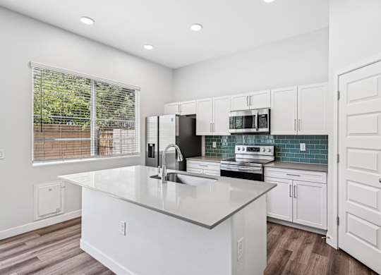 Baseline on 16th townhome kitchen with white cabinets and a large island.