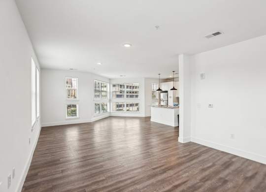 A spacious room with wooden floors and white walls.