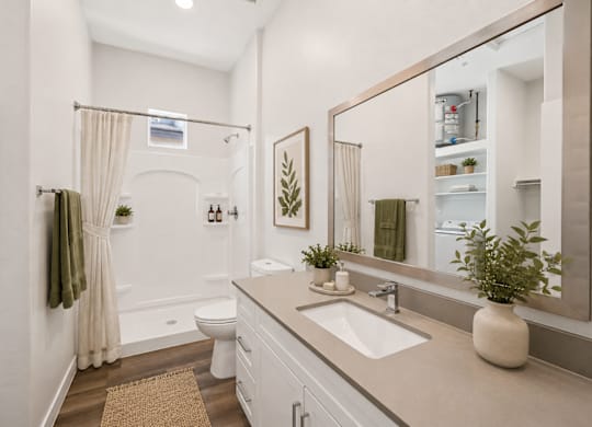A bathroom with a toilet, sink, and mirror.