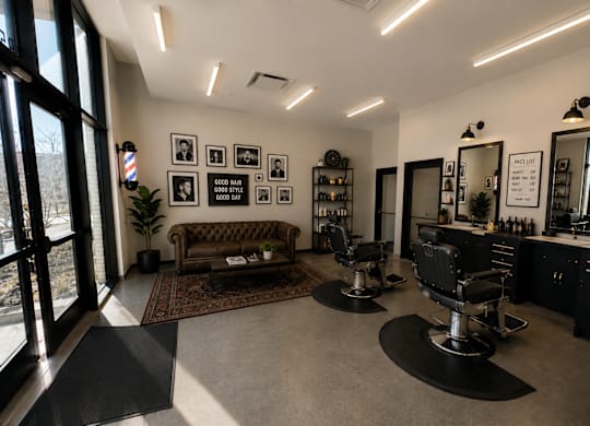 A barber shop with black chairs and a couch.