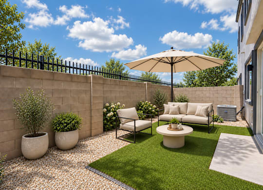 A patio with a white sofa, a table, and a large umbrella.