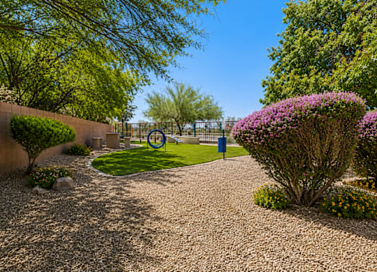 A garden with a gravel path and a blue sign in the middle.