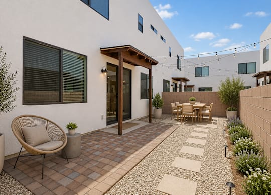 A patio with a chair and table is surrounded by a wall.