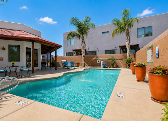 A pool with a red roof and a building behind it.