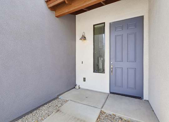 A blue door is on the right side of a white wall.