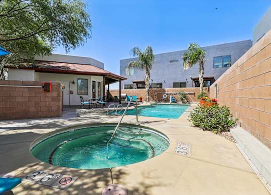 A pool with a slide and a house in the background.