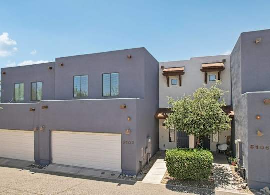 Galeria del Rio Townhome  with a tree in front of it.