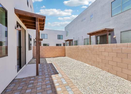 A modern building with a brick wall and a gravel pathway.