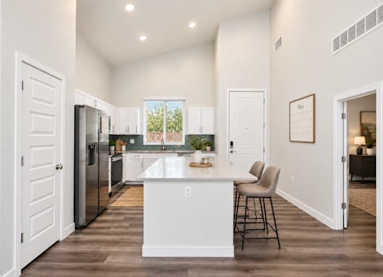A kitchen with a white island and a refrigerator.