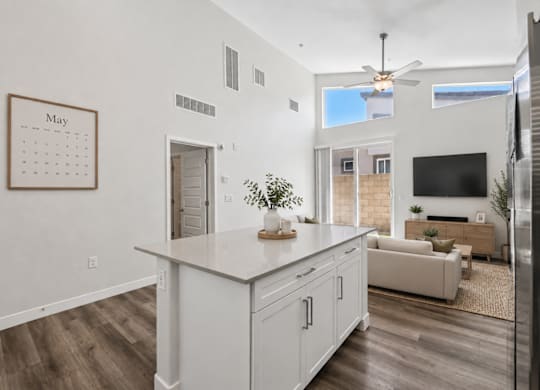 A kitchen with a calendar on the wall and a refrigerator on the right.