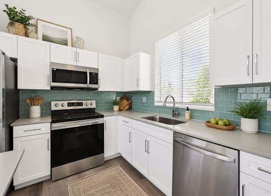 A kitchen with white cabinets and a black stove top oven.