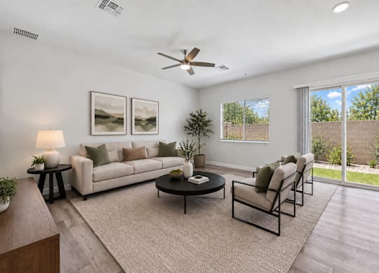 A living room with a white couch, a coffee table, and a ceiling fan.