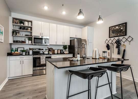 A modern kitchen with a large island and bar stools.
