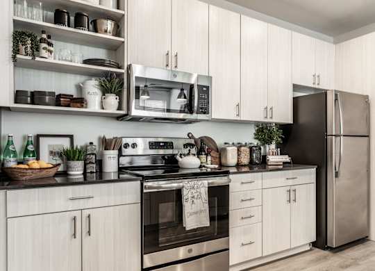 A modern kitchen with white cabinets and stainless steel appliances.