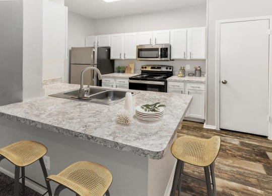 a kitchen with a marble counter top and a sink at Heatherstone, Texas