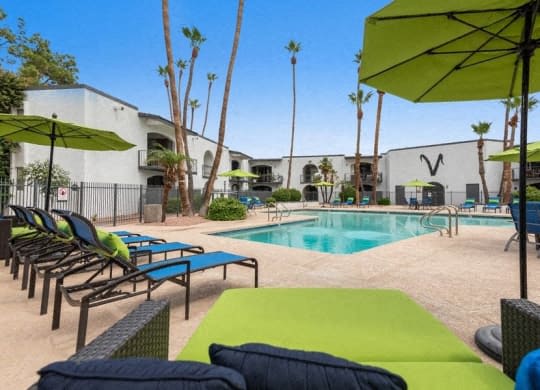 a swimming pool with lounge chairs and umbrellas at Vertu, Phoenix, Arizona