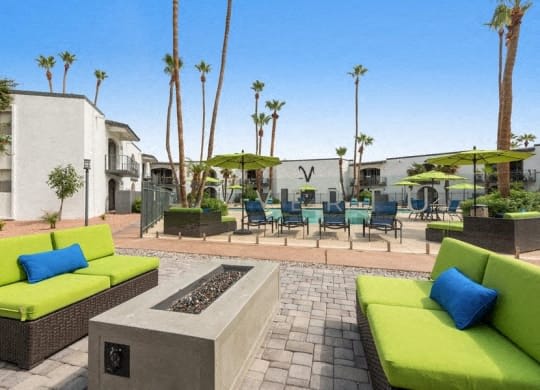 a patio with green couches and chairs and tables and palm trees at Vertu, Phoenix, AZ, 85014