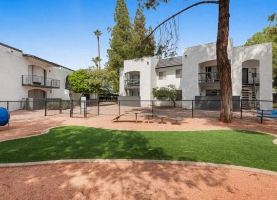 the backyard of an apartment building with a playground and grass at Vertu, Phoenix