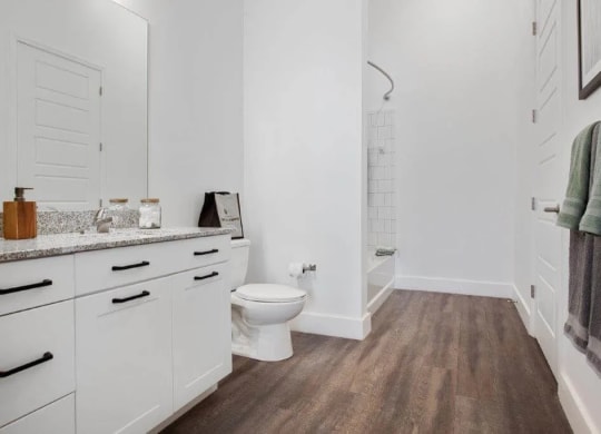 a white bathroom with a toilet and a shower at Smith and Porter, Atlanta, 30313