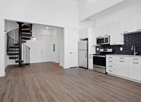 a white kitchen with a spiral staircase in the middle at Smith and Porter, Atlanta, GA